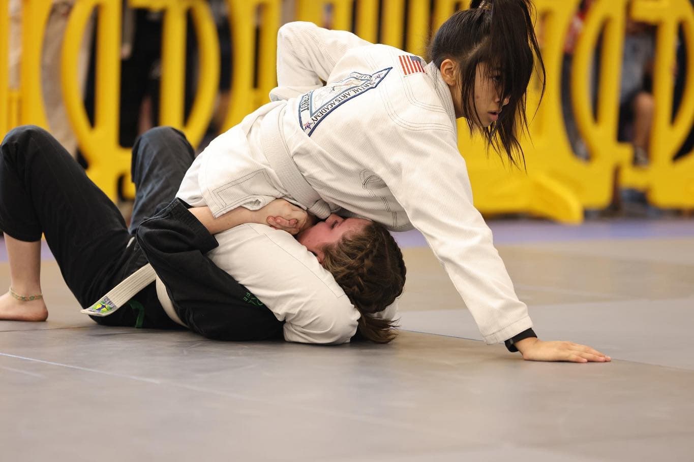 Young student finishing a triangle in a jiu-jitsu match